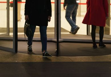 People leaving an office via a revolving door