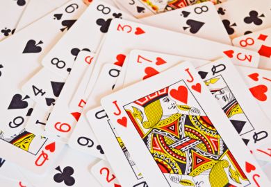 Playing cards randomly piled, with J on top