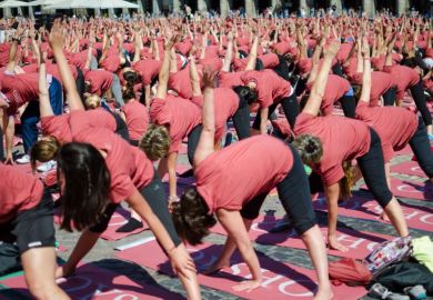 Crowd of women in pink shirts practicing stretching in the Plaza Mayor in Madrid capital of Spain
