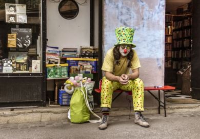 A man in a clown costume sitting and smoking cigarettes in front of an antique bookstore. A man in a clown costume sitting and smoking cigarettes in front of an antique bookstore.
