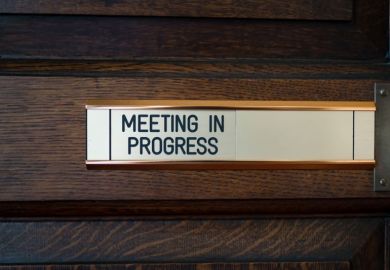 Close-up of sign on door saying 'Meeting in progress'