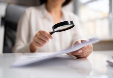 Woman looks at document with magnifying glass Woman looks at document with magnifying glass