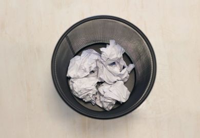 Wastepaper bin from above, with scraps of paper in it