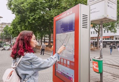 Oman passenger using digital touch-screen terminal display with information about bus and train routes Oman passenger using digital touch-screen terminal display with information about bus and train routes