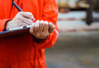 Close-up of some hands holding a clipboard and writing something