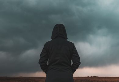 A person with their back to the camera looks at a big grey cloud A person with their back to the camera looks at a big grey cloud