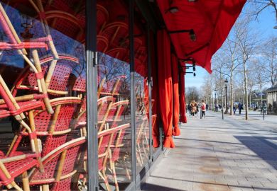 Stacked chairs inside a closed restaurant in Paris