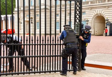 Police officers trying to close one of the gates of Buckingham Palace