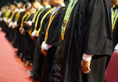 Graduates wearing gowns and sashes at their college commencement ceremonies Graduates wearing gowns and sashes at their college commencement ceremonies