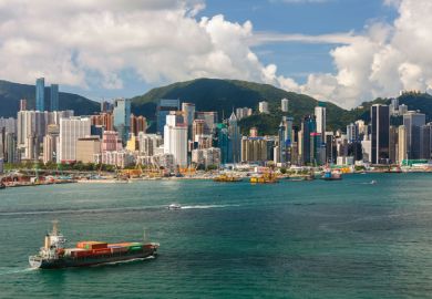 Container Ship and Hong Kong Victoria Harbour Skyline.