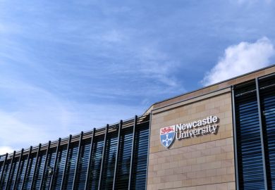  Newcastle University Kings Gate building, with university logo and lettering against sandstone wall