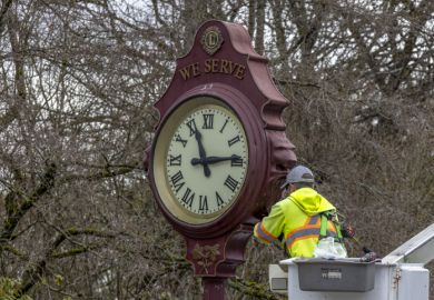 A close up of a city of Vancouver worker fixing an outdoor public clock at the Queen Elizabeth Park in Vancouver, British Columbia.