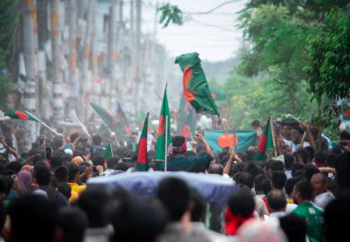 Crowds surge in streets, waving flags and chanting in celebration of student movement's victory in 2024 over oppressive regime