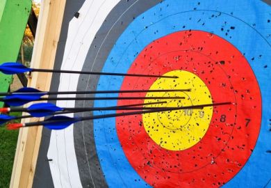 Close-Up Of A Target With Arrows Shot Into It