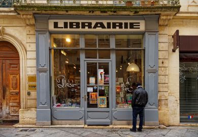 1 person is looking into an old bookstore