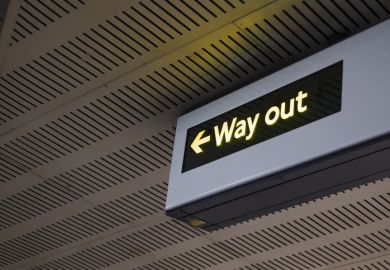 Illuminated Way Out Sign With Arrow In Modern Indoor Public Transportation Area