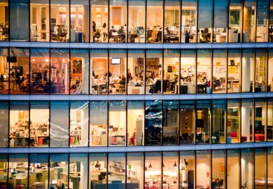 People working in the More London Riverside Estate building at dusk.