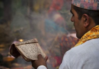 Nepalese Brahman reading Hindu religious mantras.