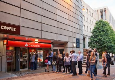 Queue of people waiting at a Santander ATM; central Edinburgh.