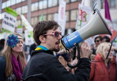 A demonstrator uses a megaphone to call for an end to the use of fossil fuels