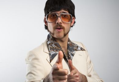 A man pulls a cheesy pose in 1970s clothing. Academics need to strike the right tone with their academic profiles if they want to attract PhD students.