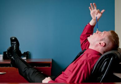 Complacent man balances pencil on nose