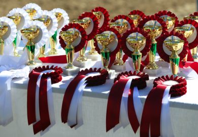 Close-up of golden trophy and ribbons for equestrian winners