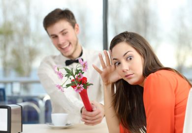 A young man offers a young woman some flowers, but she looks horrified at the camera