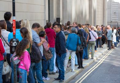 A long queue of people in a street A long queue of people in a street