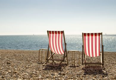 Two empty deckchairs on a stony beach to represent brain drain of graduates from English coastal towns 