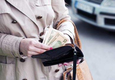A woman puts some dollars into her purse