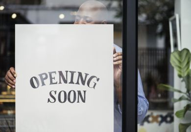 Man putting “store opening” sign in shop window