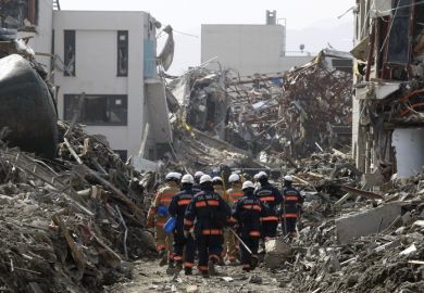 Rescue Team searching operation on debris and mud covered at Tsunami hit Destroyed city in Rikuzentakata on March 20, 2011, Japan.