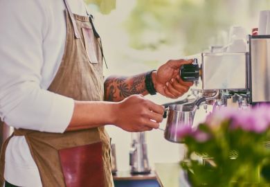 Close up image of a man preparing late in a coffee machine.