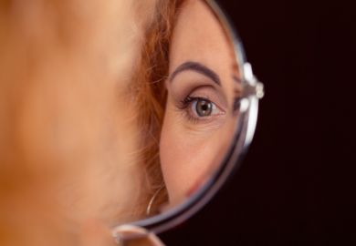 istock self-scrutiny A woman's eye reflected in a mirror