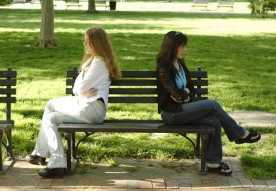 Two people facing away from each other on a bench