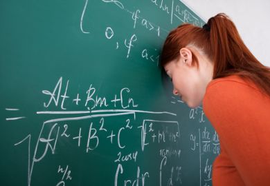 Student leaning head on blackboard