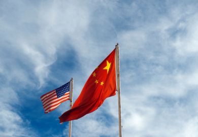 US and China flags  US and China flags against blue sky