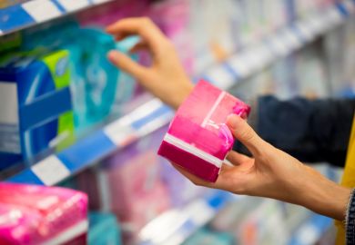 Woman choosing feminine hygiene products in supermarket