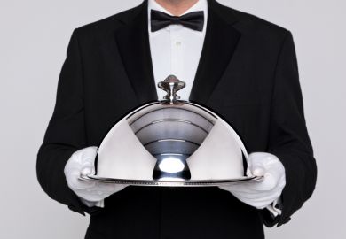 Waiter holding a silver cloche