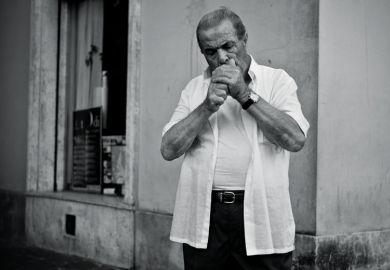 Italian man cupping hands to light cigarette