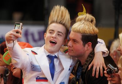 Jedward taking a selfie with a fan illustrating the academic star system