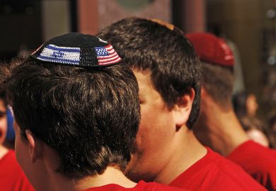Young man wearing yarmulke with American and Israeli flags