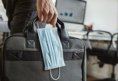 A person carrying a surgical mask and a briefcase, symbolising working during the Covid-19 pandemic