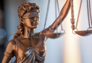 A statue of justice illustrating opinion article about double-blind peer review