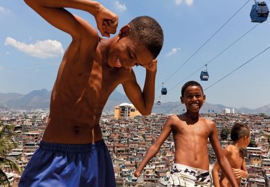 Children play near cable cars that cross over Complexo do Alemao in Rio de Janeiro, Brazil