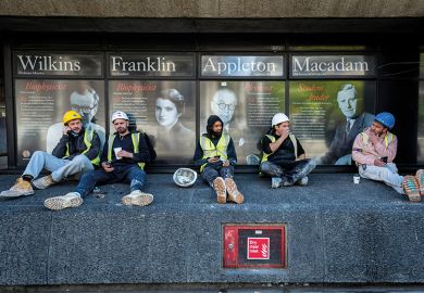 Workmen sit on a wall outside King’s College London
