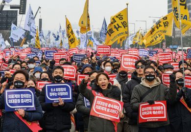 South Korean doctors hold placards saying "Opposition to the increase in medical schools" to illustrate Row over doctors’ training thwarts Korean president