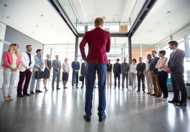 Leadership exemplified by a person in a red blazer addressing a group of diverse professionals gathered in a semicircle, in a bright modern office setting Leadership exemplified by a person in a red blazer addressing a group of diverse professionals gathered in a semicircle, in a bright modern office setting