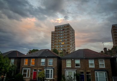 London. UK-05.17.2022. Semi detached houses and a local council social housing block of flats in a typical suburb of the capital with cloudy sunset sky.